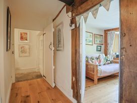 A hallway with a sofa and framed artwork at Church Farmhouse in Winsham