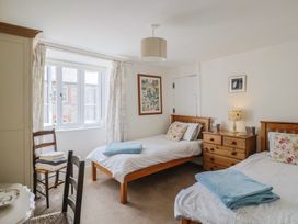 A bedroom with two beds and a chair at Church Farmhouse in Winsham