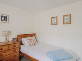 A bedroom with a single bed and a dresser at Church Farmhouse in Winsham