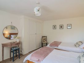 A bedroom with two beds and a table with a mirror at Church Farmhouse in Winsham