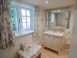 A bathroom with a sink and a mirror at Church Farmhouse in Winsham