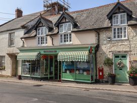 A post office store with green and white awnings in Winsham