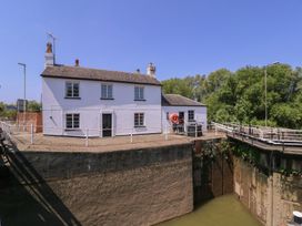 A house by a dock with a life buoy and bridge at The Lock House in Gloucester
