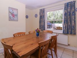 A dining room with a wooden table and flowers at The Lock House in Gloucester