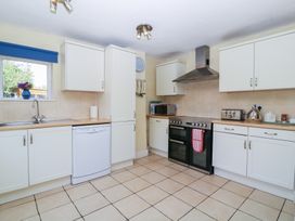 A kitchen with white cabinets and appliances at The Lock House in Gloucester