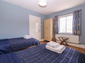 A bedroom with two beds and a wardrobe at The Lock House in Gloucester