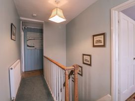A hallway with a railing and framed pictures at The Lock House in Gloucester