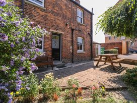 An outdoor seating area with flowers and a bench at The Lock House in Gloucester