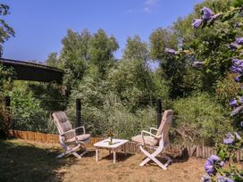 A garden with chairs and a table near a river at The Lock House in Gloucester