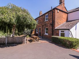 An outdoor view of a house with a tree and bench at The Lock House in Gloucester