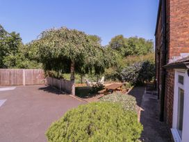 A garden with a tree, table, and chairs at The Lock House in Gloucester