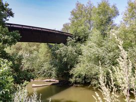 A bridge over a body of water surrounded by trees at a natural setting