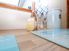 A kitchen counter with prosecco, glasses, shortbread and a bin at Min Y Traeth Bull Bay