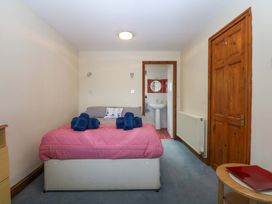 A bedroom with a bed and attached bathroom at Min Y Traeth Bull Bay