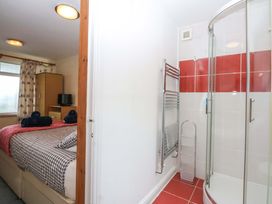 A bedroom with a bed and attached shower at Min Y Traeth in Bull Bay