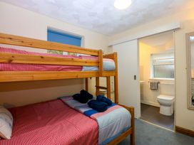 A bedroom with bunk bed and single bed at Min Y Traeth in Bull Bay