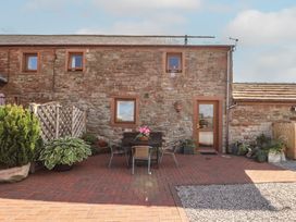 An outdoor area with a table and chairs at Piggery Cottage in Wigton