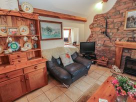A living room with a sofa and a television at Piggery Cottage in Wigton