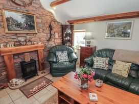 A living room with a sofa and fireplace at Piggery Cottage in Wigton