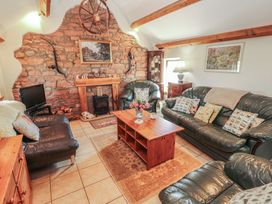 A living room with a stone fireplace at Piggery Cottage in Wigton