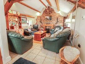 A living room with a sofa and fireplace at Piggery Cottage in Wigton