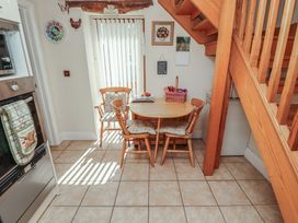 A kitchen with a round table and chairs at Piggery Cottage in Wigton