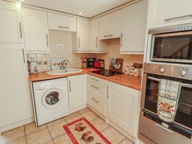 A kitchen with appliances and cabinetry at Piggery Cottage in Wigton