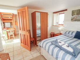 A bedroom with a bed and a mirror at Piggery Cottage in Wigton