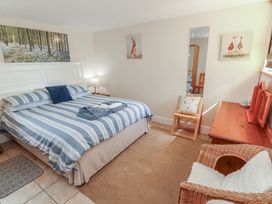 A bedroom with a bed and mirror at Piggery Cottage in Wigton