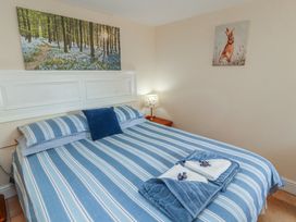 A bedroom with a bed and lamp at Piggery Cottage in Wigton