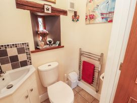 A bathroom with a sink and toilet at Piggery Cottage in Wigton