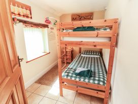 A bedroom with a bunk bed and a window at Piggery Cottage in Wigton