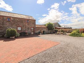 An outdoor area with a building and garden at Piggery Cottage in Wigton