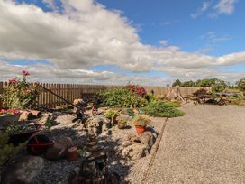 A garden with gravel path and flowers at Piggery Cottage in Wigton