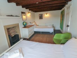 A bedroom with two beds and a fireplace at 1 Brow Cottages Green End near Goathland