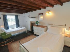 A bedroom with two beds and a dresser at 1 Brow Cottages in Green End near Goathland