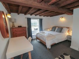 A bedroom with a bed, desk, and dresser at 1 Brow Cottages Green End near Goathland