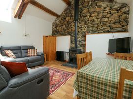 A living room with a sofa, television, and dining table at Bythyn Ddol Hafod in Capel Curig