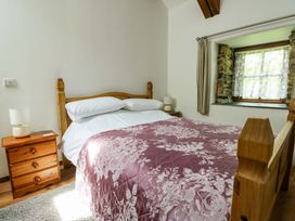 A bedroom with a bed and bedside table at Bythyn Ddol Hafod in Capel Curig