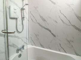 A shower and bathtub in a bathroom at Bythyn Ddol Hafod in Capel Curig