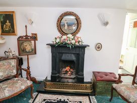 A living room with a fireplace and floral arrangement at The Farmhouse in Dunmanway, County Cork