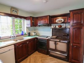 A kitchen with wooden cabinets and appliances at The Farmhouse in Dunmanway, County Cork