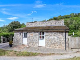 A stone building with double doors and a gravel path at The Lambing Shed in Dyserth near Prestatyn