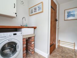 A laundry room with a washing machine and sink at The Lambing Shed in Dyserth near Prestatyn