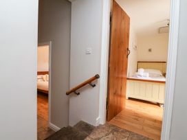 A staircase leading to a bedroom with a bed in The Lambing Shed Dyserth near Prestatyn