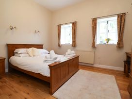 A bedroom with a bed and two windows at The Lambing Shed in Dyserth near Prestatyn