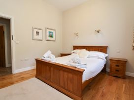 A bedroom with a wooden bed and bedside table at The Lambing Shed Dyserth near Prestatyn