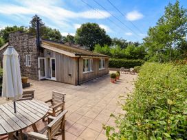 An outdoor area with a house, table, chairs, and plants at The Lambing Shed Dyserth near Prestatyn