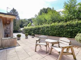 A garden with wooden chairs and a table at The Lambing Shed Dyserth near Prestatyn
