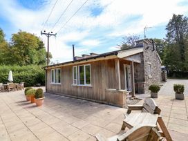 An outdoor view of a wooden building and patio area at The Lambing Shed Dyserth near Prestatyn